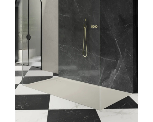 Begehbare Dusche mit Duschwanne, Glaswand und Armatur vor gefliester Wand