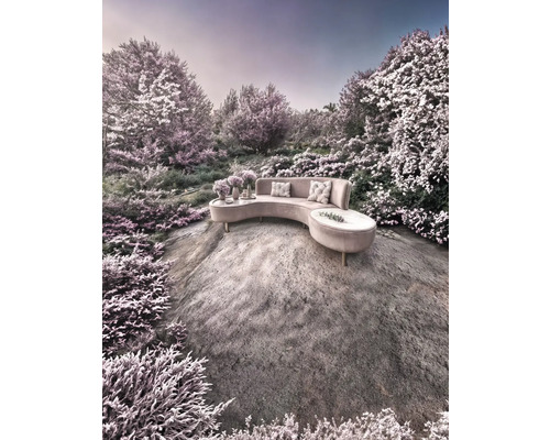 Canapé demi-lune avec coussins et tables d'appoint sur un rocher dans un paysage de jardin.