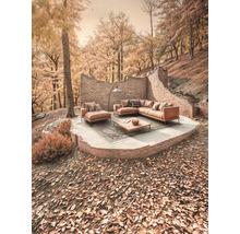 Außensitzbereich mit Sofagarnitur, Couchtisch und Backsteinmauer in herbstlicher Umgebung.