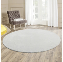Tapis rond dans le salon avec fauteuil et lumière naturelle.