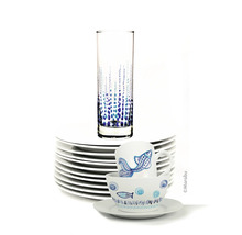 Pile d'assiettes, un verre à motif à pois et de la vaisselle à motifs de poissons