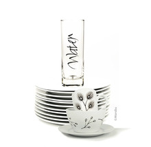 Pile d'assiettes blanches avec tasse à thé, soucoupe et verre à eau