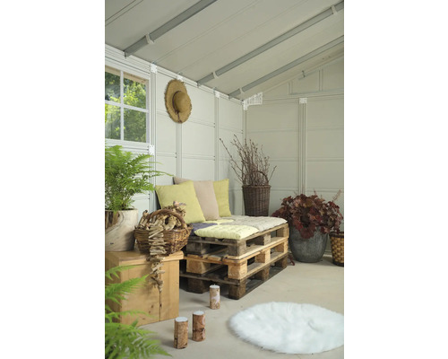Coin salon confortable dans une cabane de jardin avec des meubles en palettes, des coussins et des plantes