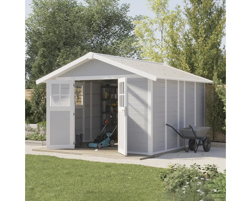 Abri de jardin avec portes ouvertes, tondeuse à gazon et brouette dans le jardin
