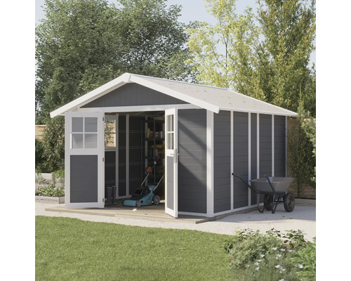 Abri de jardin avec portes doubles ouvertes, tondeuse à gazon et brouette dans le jardin