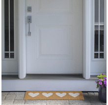 Paillasson avec motifs de cœurs devant une porte d'entrée