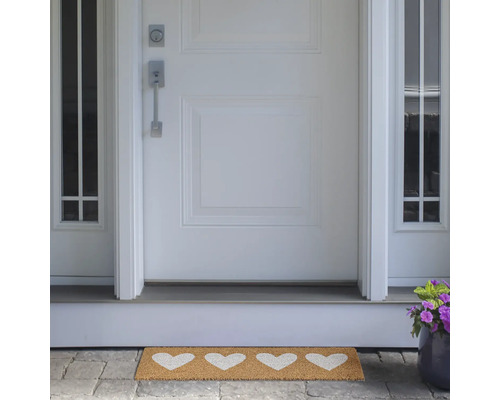 Paillasson avec motifs de cœurs devant une porte d'entrée
