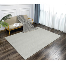Salon avec canapé et tapis à chevrons sur parquet