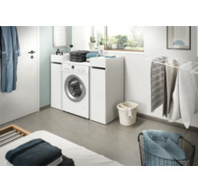 Salle de bain lumineuse avec machine à laver et accessoires de lessive