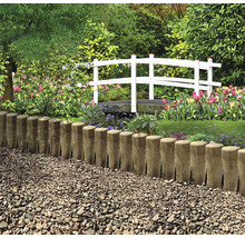 Jardin avec clôture en bois, chemin de gravier et pont blanc