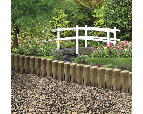 Jardin avec clôture en bois, chemin de gravier et pont blanc