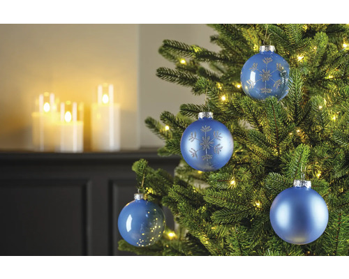 Nahaufnahme von blauem Christbaumschmuck an einem Weihnachtsbaum mit Lichtern