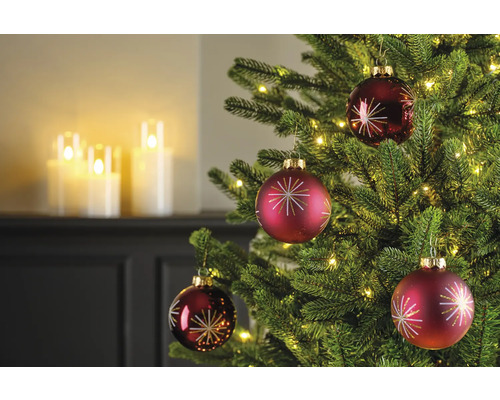 Nahaufnahme eines Weihnachtsbaums mit roten Christbaumkugeln und Lichtern