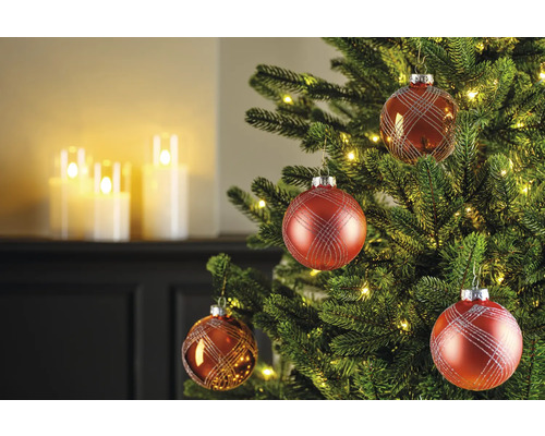 Geschmückter Weihnachtsbaum mit roten Christbaumkugeln und warmweißen Lichtern