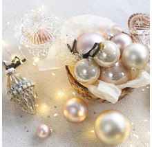 Boules de Noël décoratives dans un bol et guirlande lumineuse.