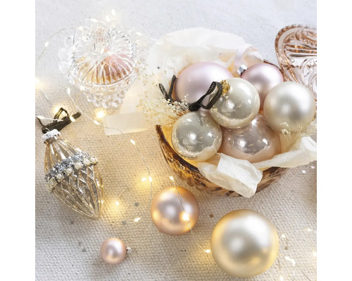 Boules de Noël décoratives dans un bol et guirlande lumineuse.