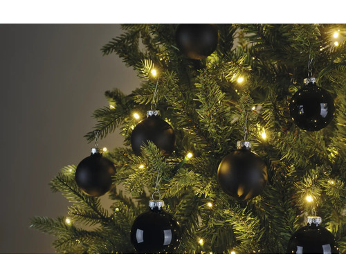 Nahaufnahme eines Weihnachtsbaums mit schwarzen Christbaumkugeln und Lichterkette