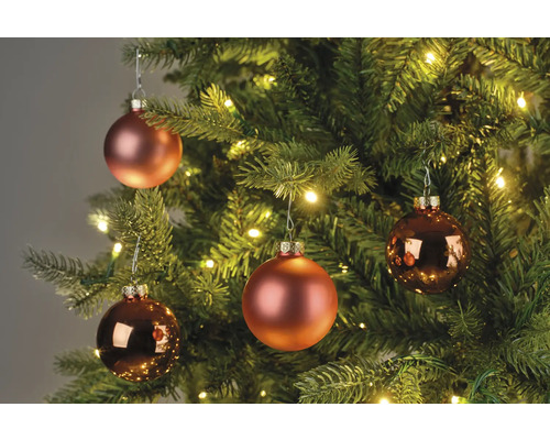 Nahaufnahme von Weihnachtskugeln an einem Weihnachtsbaum mit Beleuchtung.