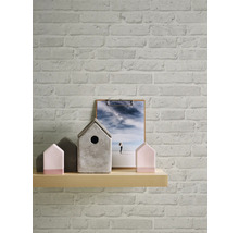 Wand mit Backsteintapete, Holzregal mit Hausdekorationen und Bild auf einem Klemmbrett