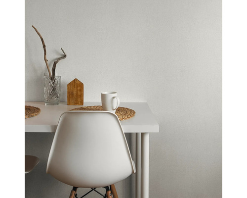 Detailansicht eines Tisches mit Dekoration und Stuhl vor einer Wand