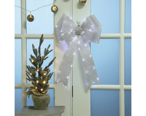 Weihnachtliche Szene mit geschmücktem Tannenbaum und Schleife mit Lichtern