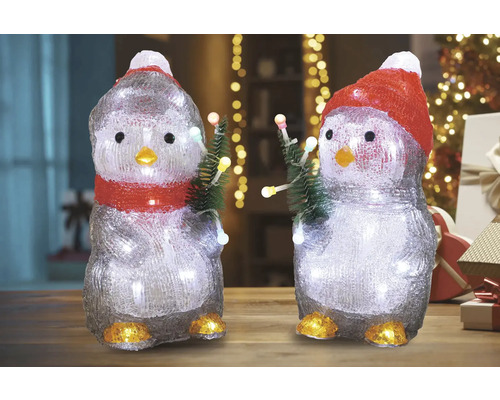Zwei Pinguinfiguren mit Beleuchtung und Weihnachtsbäumen als Dekoration