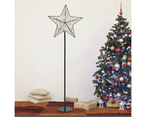 Dekorative Stern Stehlampe neben einem geschmückten Weihnachtsbaum.