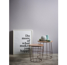 Scène décorative avec deux tables d'appoint, une inscription encadrée et des vases décoratifs.