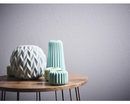 Dekorative Vasen auf einem Holztisch vor einer gemusterten Tapete