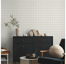 Salon avec commode, chaise et papier peint à carreaux