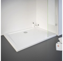 Receveur de douche rectangulaire avec design plat et bonde centrale dans un environnement de salle de bain lumineux.