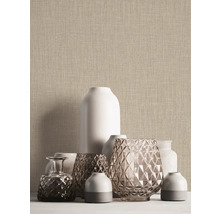 Gros plan de vases devant un papier peint structuré beige