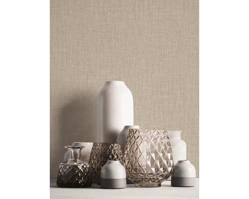 Gros plan de vases devant un papier peint structuré beige