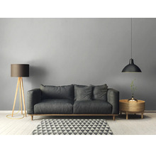 Salon avec canapé, lampadaire, suspension et table d'appoint sur un tapis géométrique