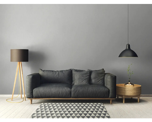 Salon avec canapé, lampadaire, suspension et table d'appoint sur un tapis géométrique
