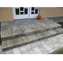 Un escalier extérieur en pavés de béton mène à la porte d'entrée