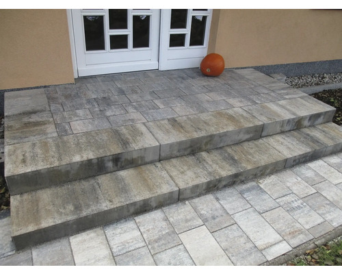Un escalier extérieur en pavés de béton mène à la porte d'entrée