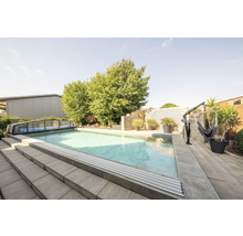 Piscine extérieure avec couverture, escalier et support de hamac dans le jardin