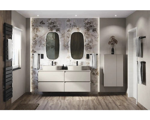 Salle de bains lumineuse avec double vasque, meuble sous-vasque, miroirs et papier peint à motifs floraux.