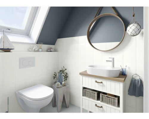 Salle de bains lumineuse avec toilettes, lavabo, miroir et fenêtre de toit