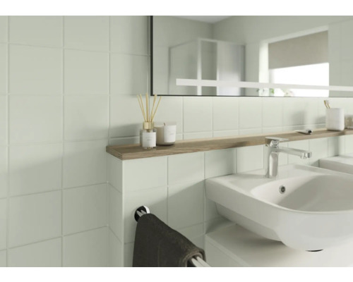 Salle de bain lumineuse avec lavabo, miroir et carrelage