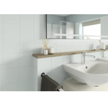 Salle de bain lumineuse avec lavabo, miroir et étagère