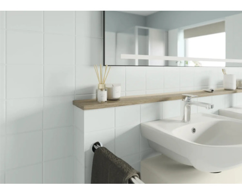 Salle de bain lumineuse avec lavabo, miroir et étagère