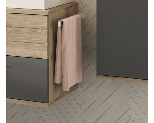 Detailansicht eines Badezimmers mit Waschtisch, Handtuch und Handtuchhalter