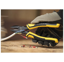 Stanley Logo. Eine Person mit Handschuhen schneidet mit einer Zange ein Kabel ab.