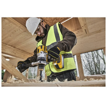 Un ouvrier perce un morceau de bois avec une perceuse DeWalt jaune.