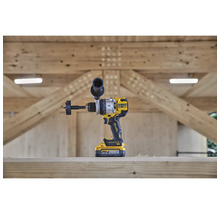 Perceuse sans fil DeWalt avec foret à fraise devant une structure en bois