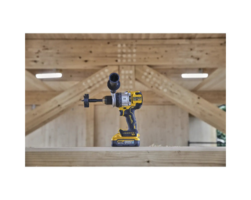 Perceuse sans fil DeWalt avec foret à fraise devant une structure en bois