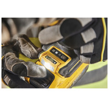 Lampe de travail jaune tenue par des mains gantées