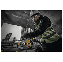Homme portant un casque et des lunettes de protection utilisant une scie circulaire portative de marque DeWalt sur un chantier